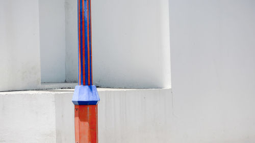 Close-up of blue pipe against white wall