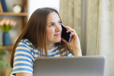 Young woman using laptop while sitting at home