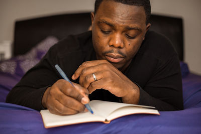 Portrait of senior man writing in book at home