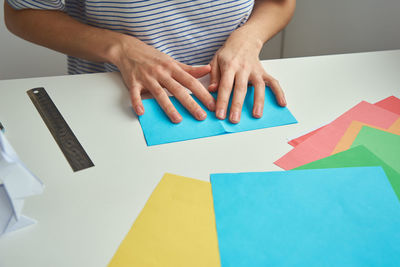 Origami lessons. woman make origami easter rabbit from color paper. diy concept