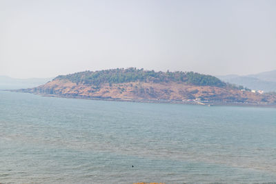 Scenic view of sea and mountains against clear sky