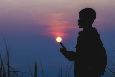 Silhouette man standing against sky during sunset