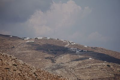 Distant view of houses on hill against sky