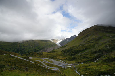 Scenic view of mountains against cloudy sky