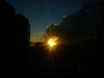 Sun shining through trees at sunset