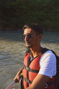 Young man rafting in river