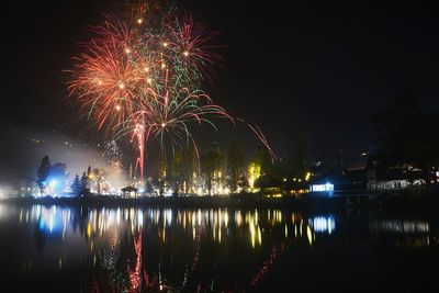 Firework display over lake at night