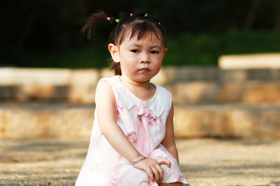 Portrait of cute girl sitting on land