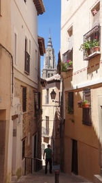 Rear view of people walking on street amidst buildings