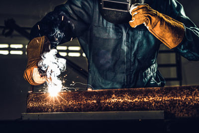 Low angle view of man working on metal