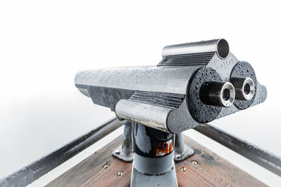 Close-up of coin-operated binoculars on pier against sky