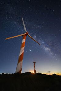 Low angle view of windmill on field against sky at night