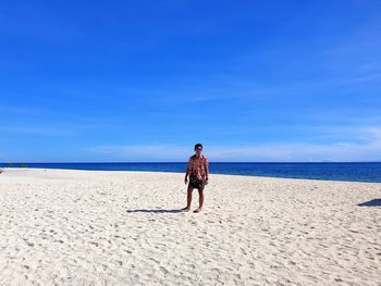 Rear view of man on beach against sky