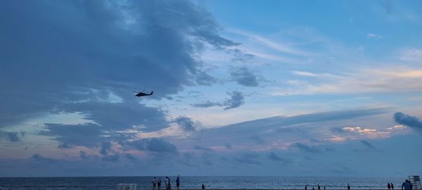 Airplane flying over sea against sky