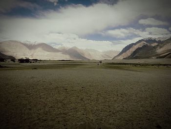 Scenic view of mountains against cloudy sky