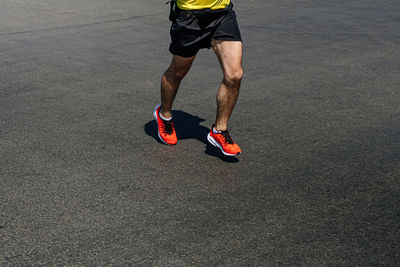 Low section of man running on street