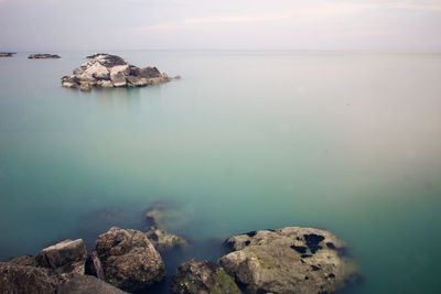 Rocks by sea against sky