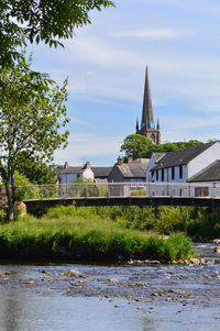 Building by river against sky