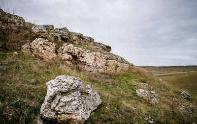 Stone wall on cliff against sky