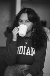 Portrait of woman drinking coffee sitting indoors