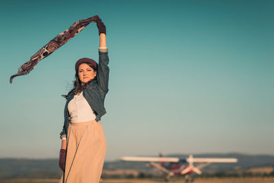 Portrait of woman standing against clear sky