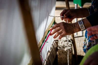 Cropped hand of woman working at textile factory