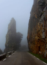 Road amidst rocks against sky