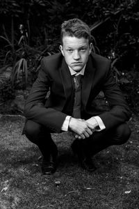 Portrait of young man sitting on land