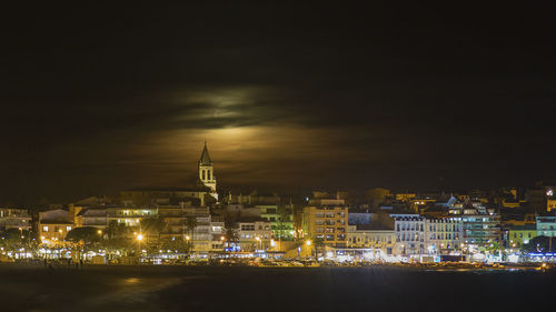 Illuminated buildings against sky at night