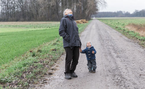 Full length of grandfather with son on dirt road