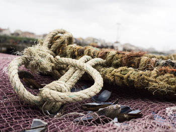 Close-up of weathered rope tied to fishing net