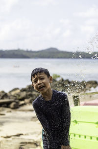 Boy crying while standing at beach