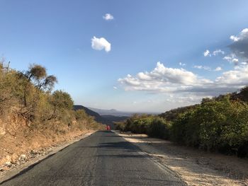 Road amidst trees against sky