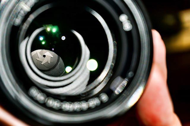 close-up, part of, indoors, photography themes, technology, focus on foreground, camera - photographic equipment, cropped, circle, selective focus, holding, person, equipment, lens - optical instrument, reflection, high angle view, digital camera