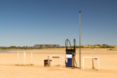 Fuel pump at desert against clear blue sky