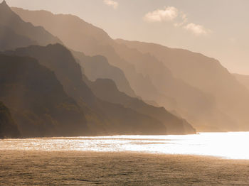 Scenic view of sea and mountains against sky