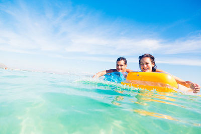 People enjoying in swimming pool against sky