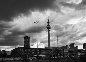 Buildings in city against cloudy sky