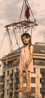 Portrait of young woman standing against built structure