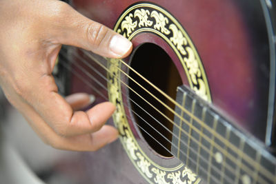 Cropped hand playing guitar