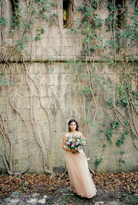 Rear view of woman standing against wall