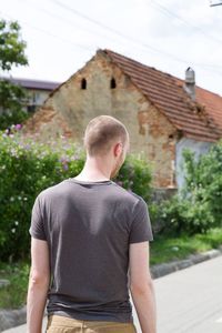 Rear view of man standing outside house