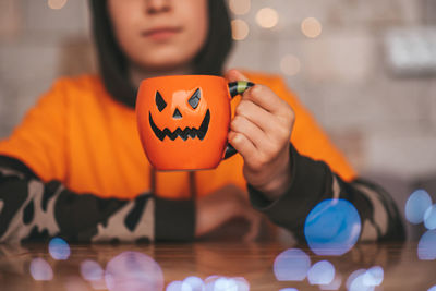 Cropped hand of woman holding jack o lantern