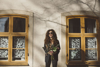 Happy woman holding bouquet of flowers