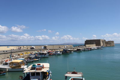 Boats sailing in sea against sky in city