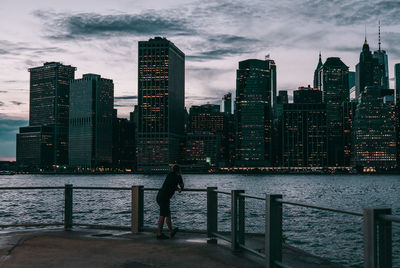 City skyline by sea against sky