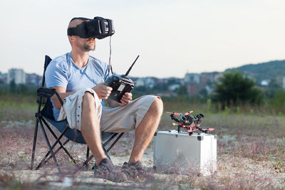 Man using virtual reality simulator with drone on field