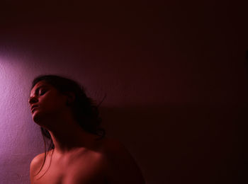 Self portrait of young woman against purple background