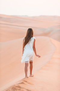 Rear view of woman standing on desert