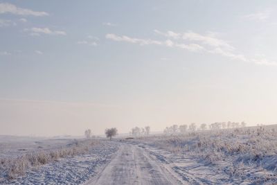 Road amidst landscape against sky during winter